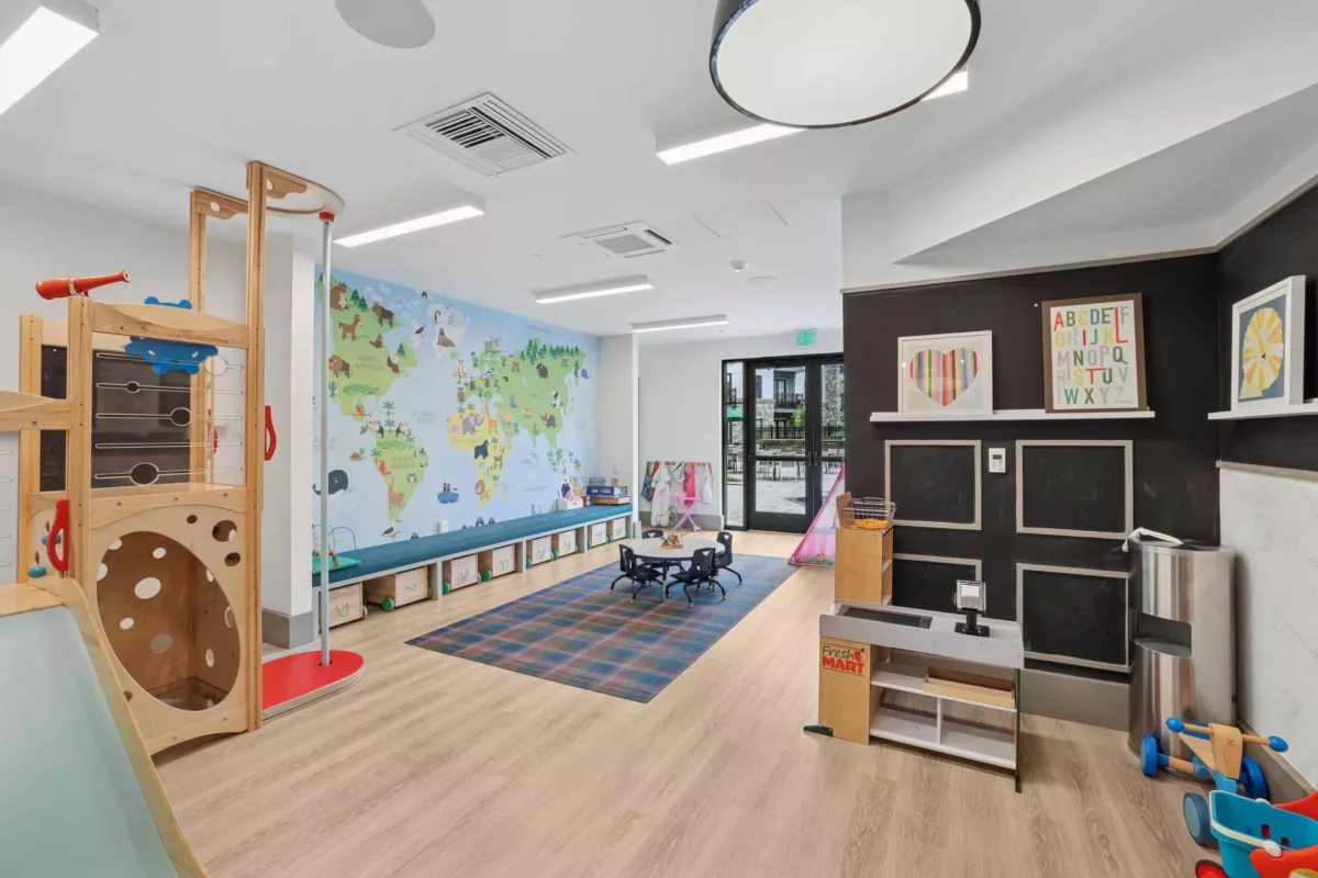Children’s playroom with wall map, wooden play set, and colorful decor.
