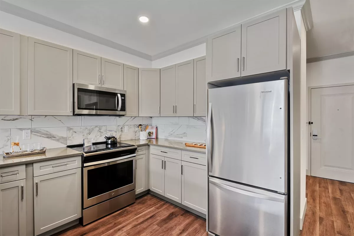 Kitchen at Carraway with range, fridge, and wood-style flooring