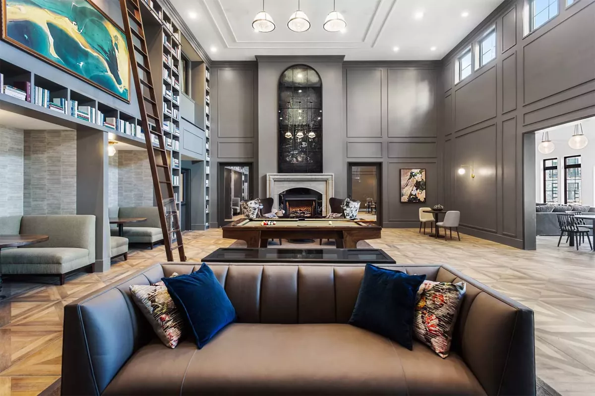 Luxury clubhouse with pool table, bookcase, and large windows for natural light