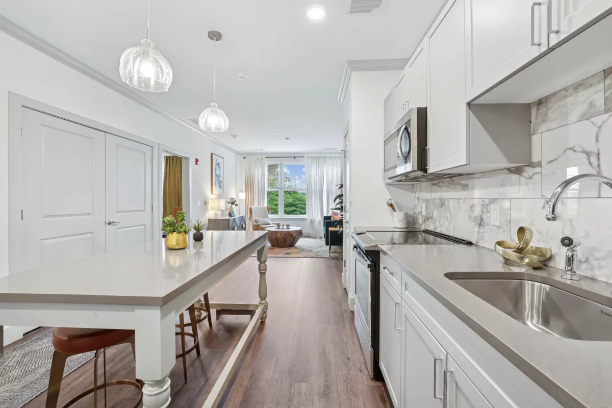 Modern kitchen with white cabinets, stone countertops, and pendant lighting.